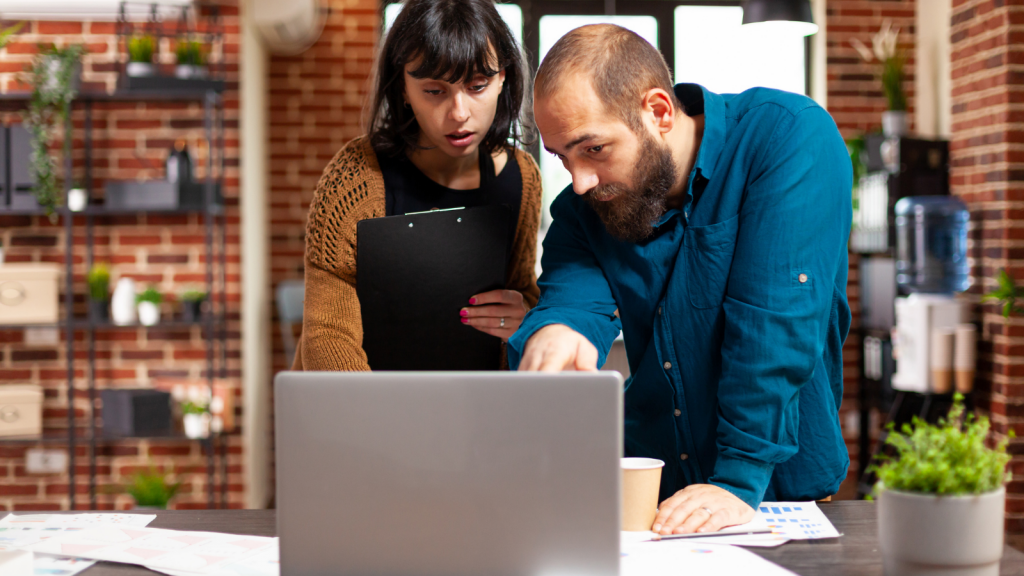 man and woman looking into a business phone system on laptop